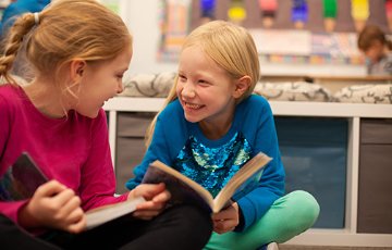 Two young children enjoying their books